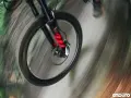 Przednie koło roweru enduro w ruchu, z widocznym amortyzatorem. Różne rodzaje amortyzatorów wpływają na jazdę.