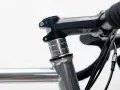 Czarne stery rowerowe PRO z aluminiowymi podkładkami, zamontowane na szarej ramie roweru szosowego.