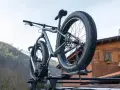 Gotowy montaż bagażnika rowerowego na dachu samochodu. Grube opony roweru fat bike są gotowe na przygodę.