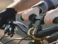 Dziecko trzyma kierownicę roweru, gotowe do jazdy. Wymiana manetek w rowerze to dobry pomysł na ulepszenie.