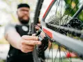 Mężczyzna z brodą dokręca śruby w rowerze, dbając o każdy szczegół.