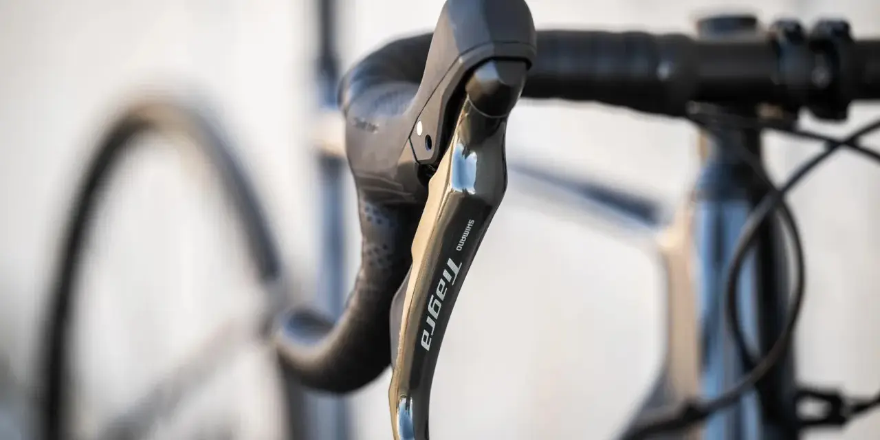 Klamka Shimano Tiagra na kierownicy szosowej. Dowiedz się, jak dobrać szerokość kierownicy szosowej dla optymalnej pozycji.