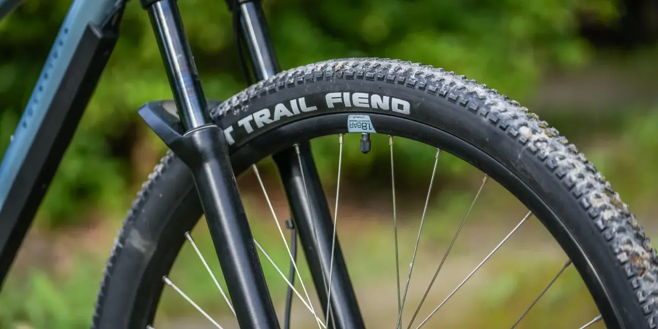 Opona rowerowa "Trail Fiend" z widocznym bieżnikiem, czy to opona drutowa czy zwijana, gotowa na terenowe wyzwania.