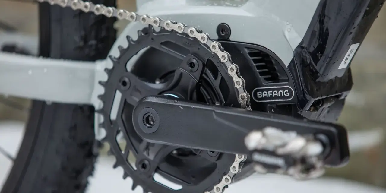 Czyszczenie łańcucha rowerowego to klucz do płynnej jazdy. Widoczny mechanizm korbowy z napędem Bafang i metalowy łańcuch.