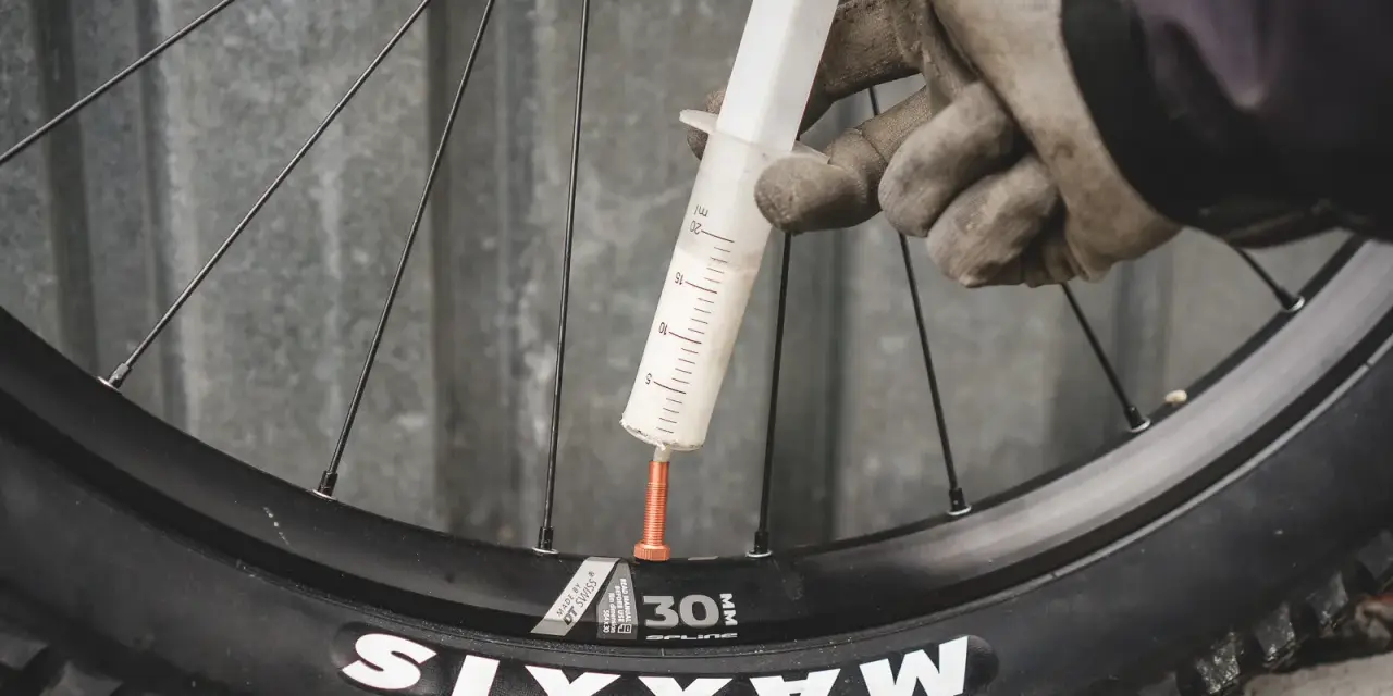 Rękawiczki i strzykawka z mleczkiem do opony tubeless.
