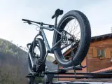 Gotowy montaż bagażnika rowerowego na dachu samochodu. Grube opony roweru fat bike są gotowe na przygodę.
