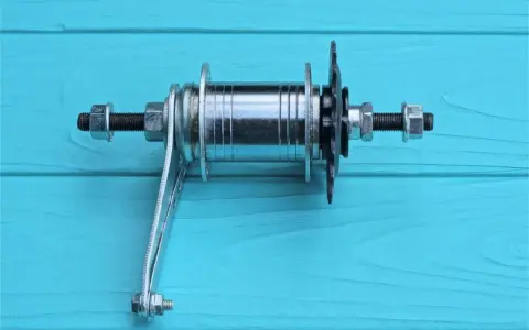 Bębenek piasty rowerowej Shimano SIS z zębatkami i nakrętkami, gotowy do montażu.