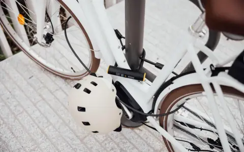 Biały rower z kaskiem i zapięciem. Zapomniałem kod do blokady rowerowej, co teraz?