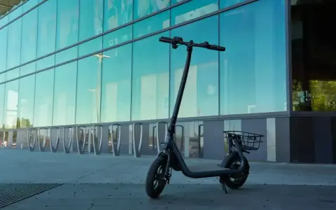 Czarny hulajnoga elektryczna z koszykiem, gotowa na długie trasy. Wyobraź sobie, że ten rower elektryczny zasięg 300 km pozwoli Ci odkryć całe miasto bez ładowania!
