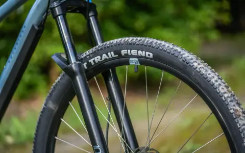 Opona rowerowa "Trail Fiend" z widocznym bieżnikiem, czy to opona drutowa czy zwijana, gotowa na terenowe wyzwania.