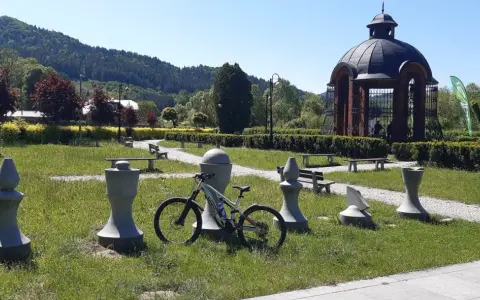 Rower czeka na odkrywanie muszyna tras rowerowych. W tle altana i góry.