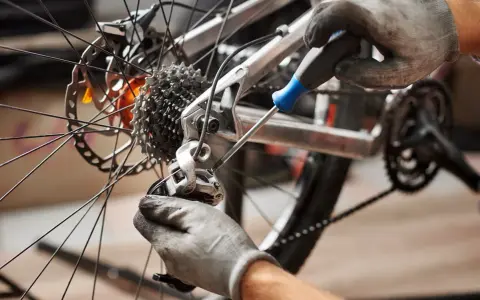 Mechanik reguluje przerzutkę, by zapobiec przeskakującemu łańcuchowi w rowerze.