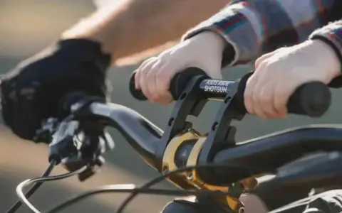 Dziecko trzyma kierownicę roweru, gotowe do jazdy. Wymiana manetek w rowerze to dobry pomysł na ulepszenie.
