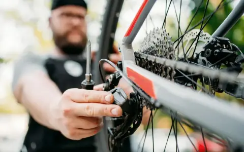 Mężczyzna z brodą dokręca śruby w rowerze, dbając o każdy szczegół.
