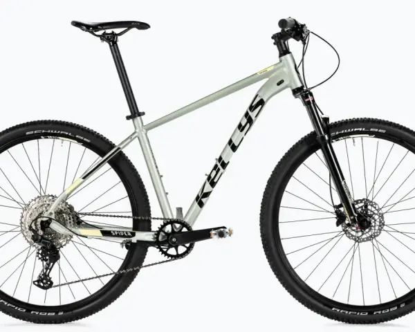 Szary rower Kellys Spider, rower bez amortyzatora, z czarnymi oponami Schwalbe i przerzutkami Shimano.