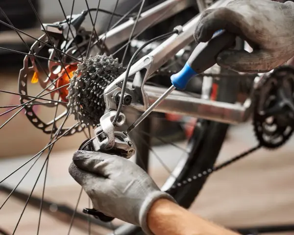 Mechanik reguluje przerzutkę, by zapobiec przeskakującemu łańcuchowi w rowerze.