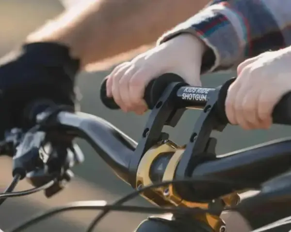 Dziecko trzyma kierownicę roweru, gotowe do jazdy. Wymiana manetek w rowerze to dobry pomysł na ulepszenie.