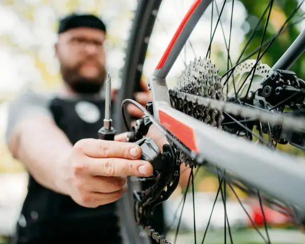 Mężczyzna z brodą dokręca śruby w rowerze, dbając o każdy szczegół.