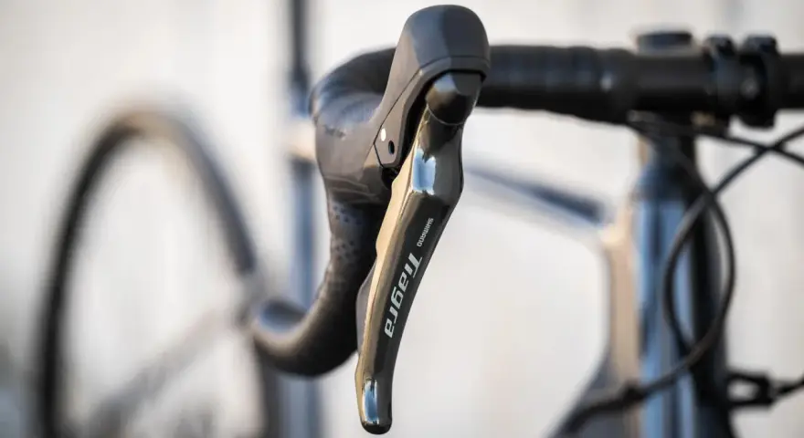 Klamka Shimano Tiagra na kierownicy szosowej. Dowiedz się, jak dobrać szerokość kierownicy szosowej dla optymalnej pozycji.