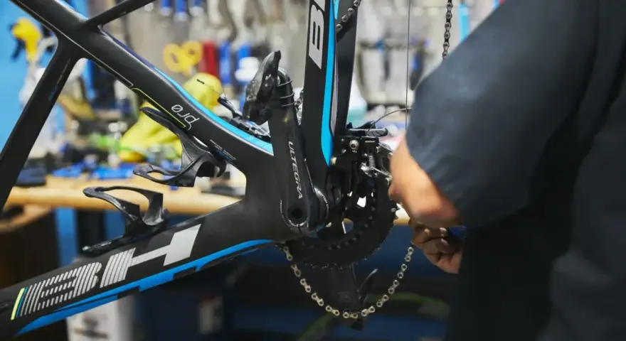 Mechanik reguluje ustawienie przedniej przerzutki w rowerze szosowym BH.
