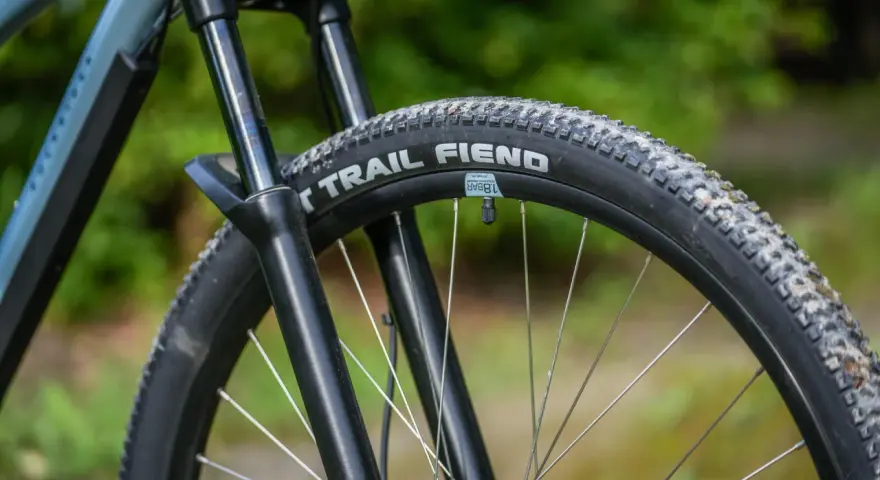 Opona rowerowa "Trail Fiend" z widocznym bieżnikiem, czy to opona drutowa czy zwijana, gotowa na terenowe wyzwania.