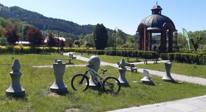 Rower czeka na odkrywanie muszyna tras rowerowych. W tle altana i góry.