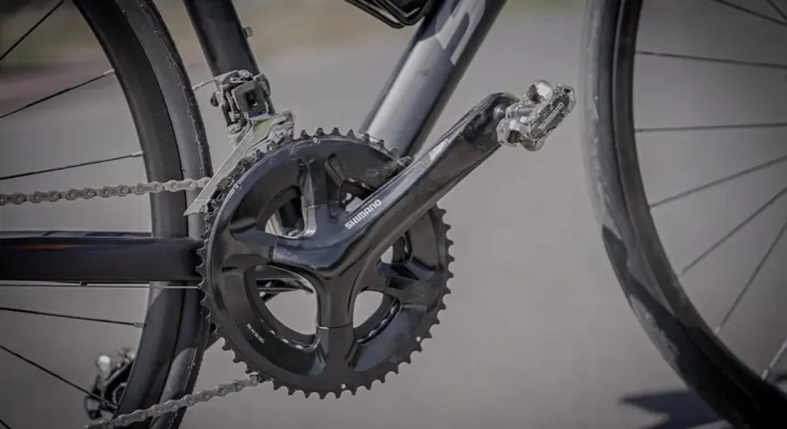 Mechanizm korbowy roweru z widoczną numeracją przerzutek Shimano.