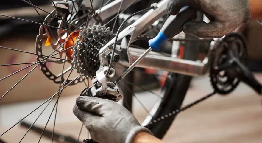 Mechanik reguluje przerzutkę, by zapobiec przeskakującemu łańcuchowi w rowerze.
