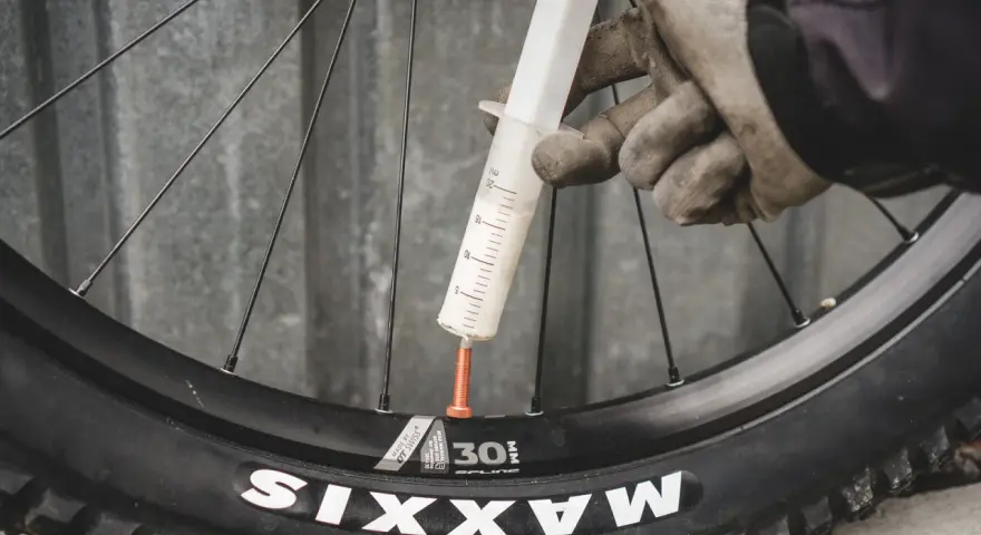 Rękawiczki i strzykawka z mleczkiem do opony tubeless.