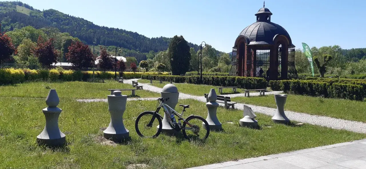 Rower czeka na odkrywanie tras rowerowych w Muszynie. W tle altana i g&oacute;ry.