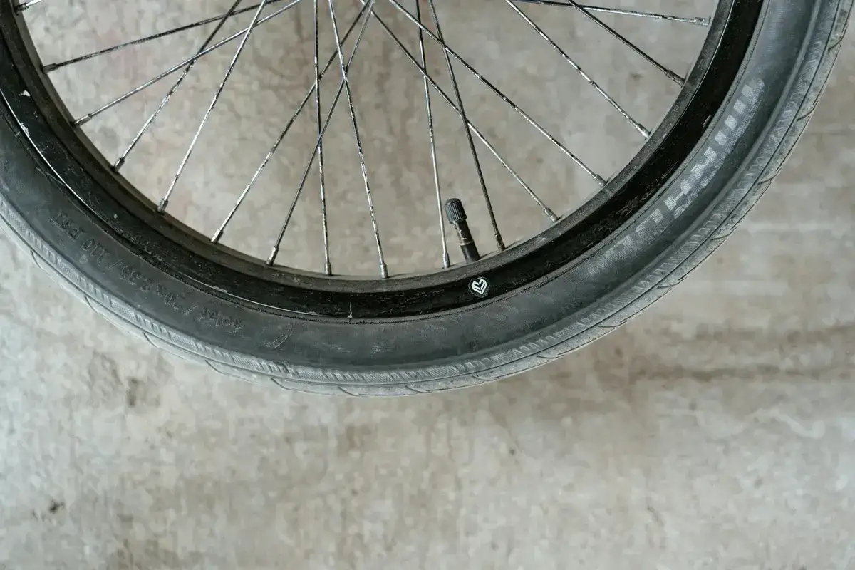 Zużyta opona rowerowa leży na betonie. Zastanawiasz się, gdzie wyrzucić opony rowerowe? Sprawdź lokalne punkty zbiórki odpadów.
