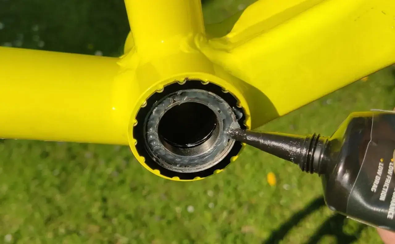 Smarowanie gwintów przed wymianą suportu w rowerze.