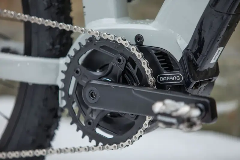 Czyszczenie łańcucha rowerowego to klucz do płynnej jazdy. Widoczny mechanizm korbowy z napędem Bafang i metalowy łańcuch.
